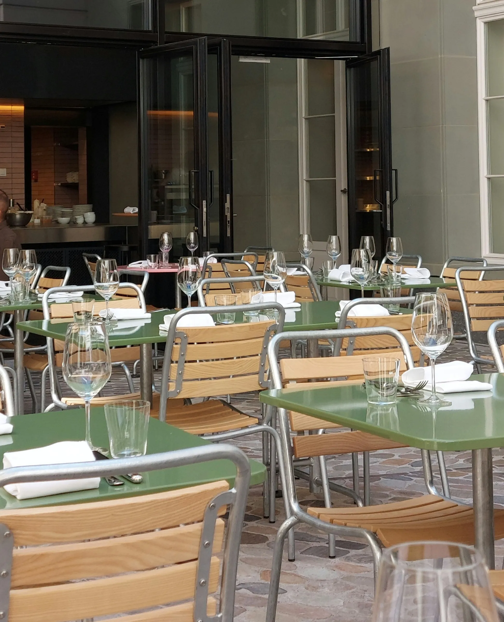 Terrasse der Brasserie Kaiser im Kaiserhaus-Innenhof mit grünen Metalltischen