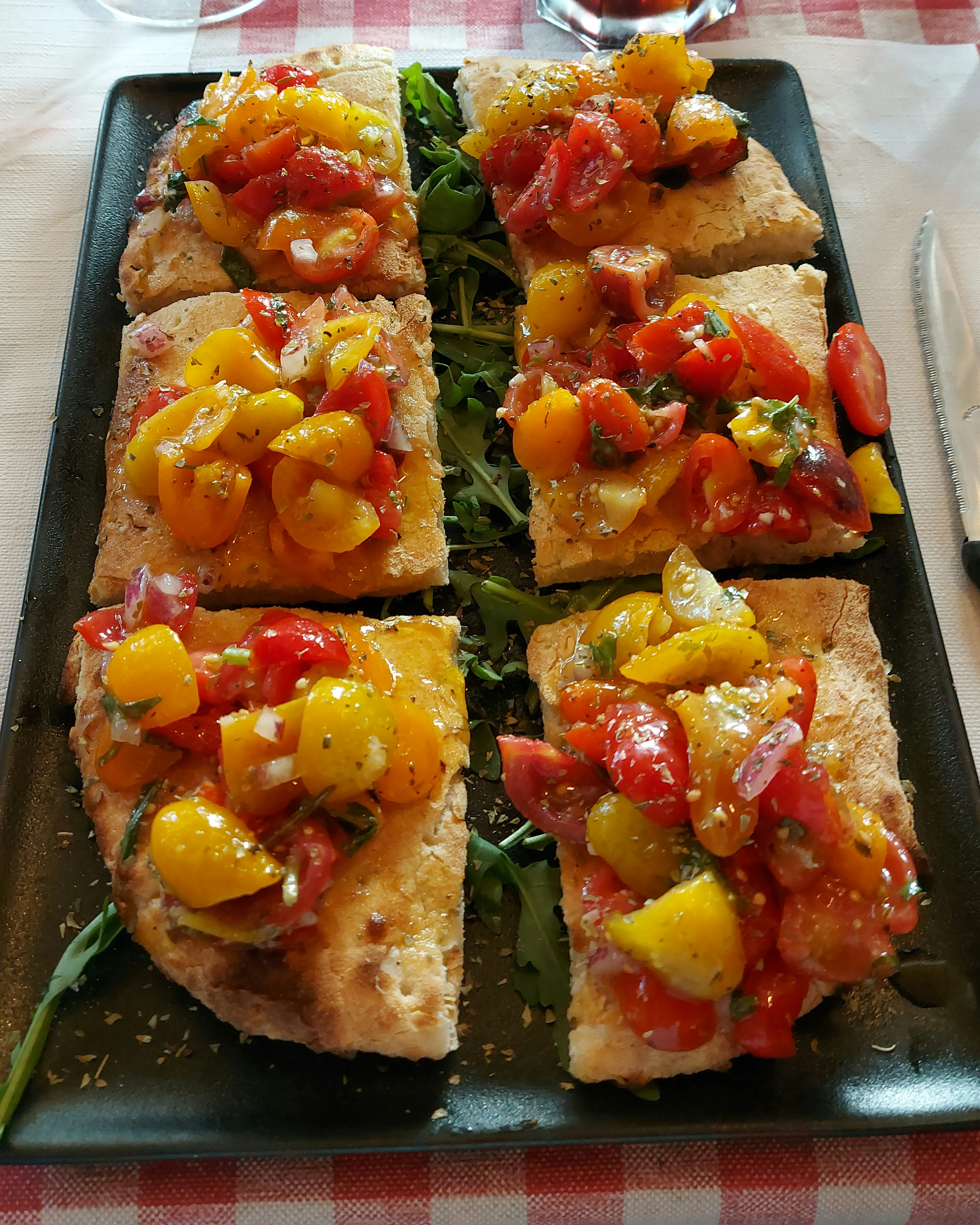 Riesige Bruschetta der Osteria da Santo, belegt mit Tomaten, Rucola und Knoblauch