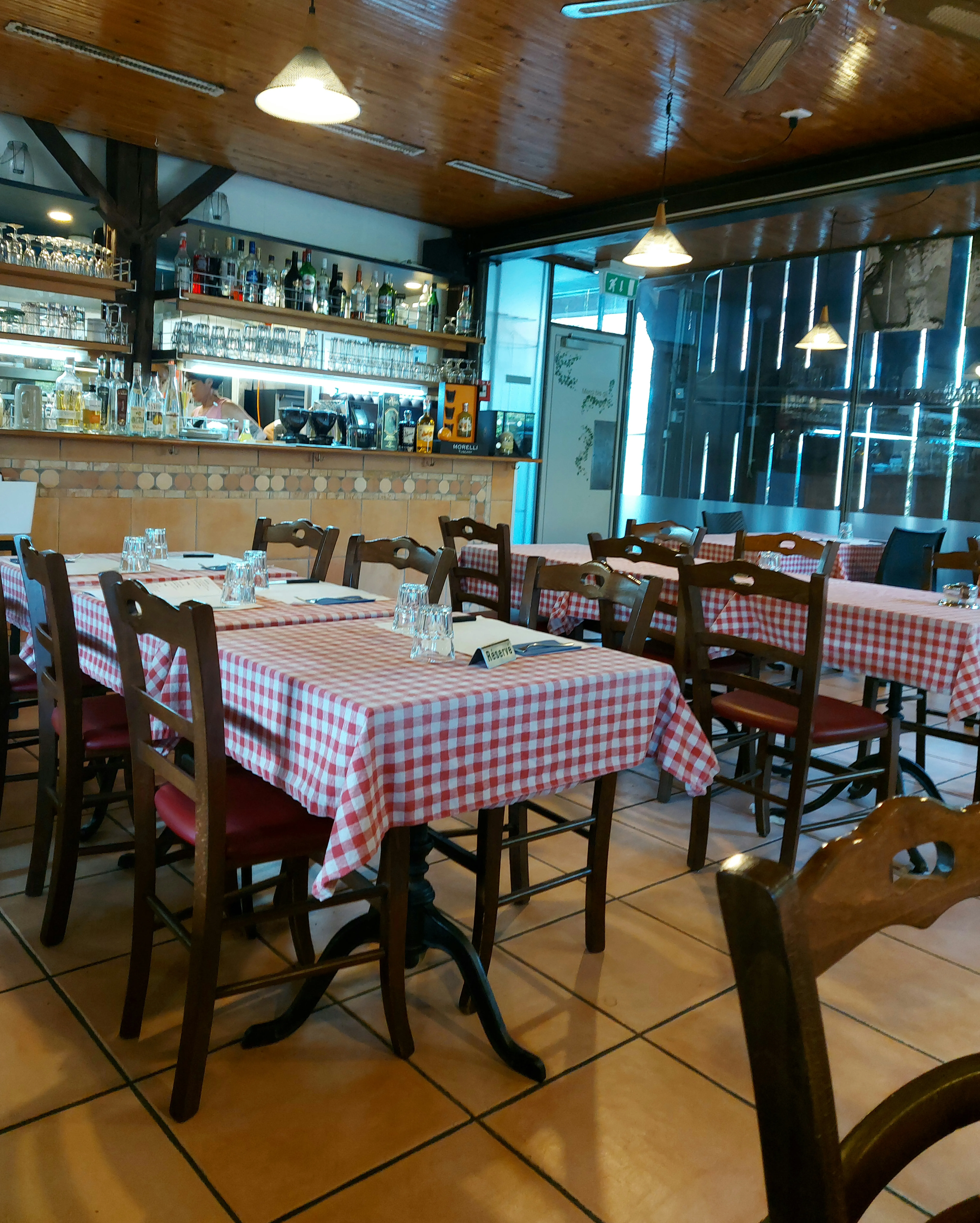 Innenraum der Osteria da Santo in Bümpliz mit Holzwänden und rustikalen Tischen