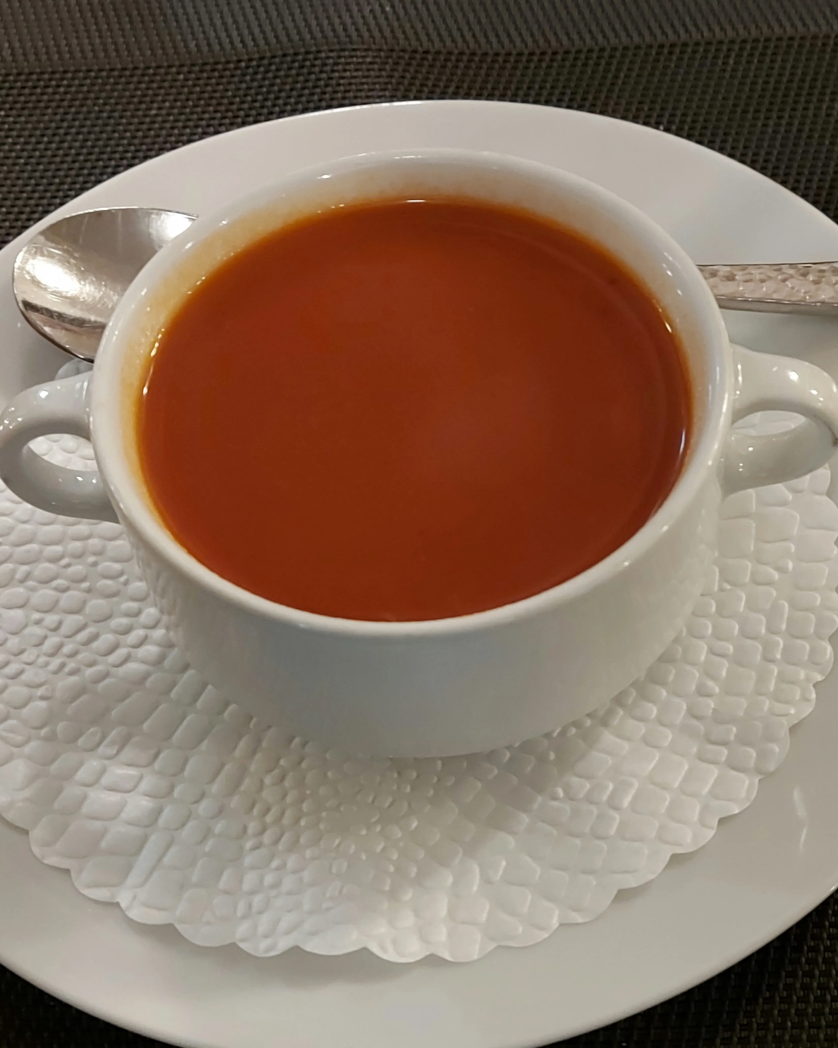 Creamy red tomato soup served in a white bowl at Della Casa Bern.