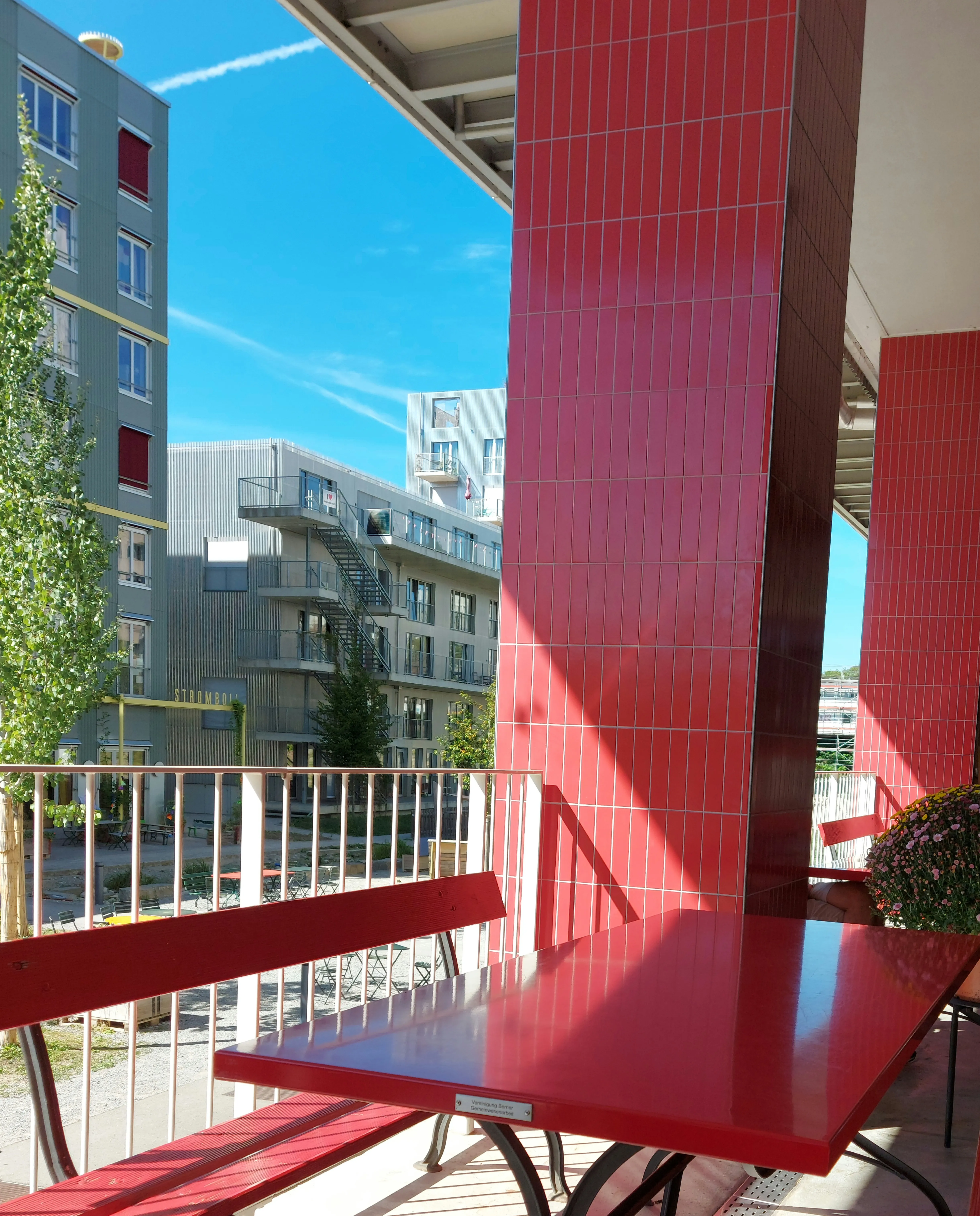 Blick vom Aussensitzplatz des DOCK8 auf die Wohnhäuser und Grünfläche der Siedlung Holliger