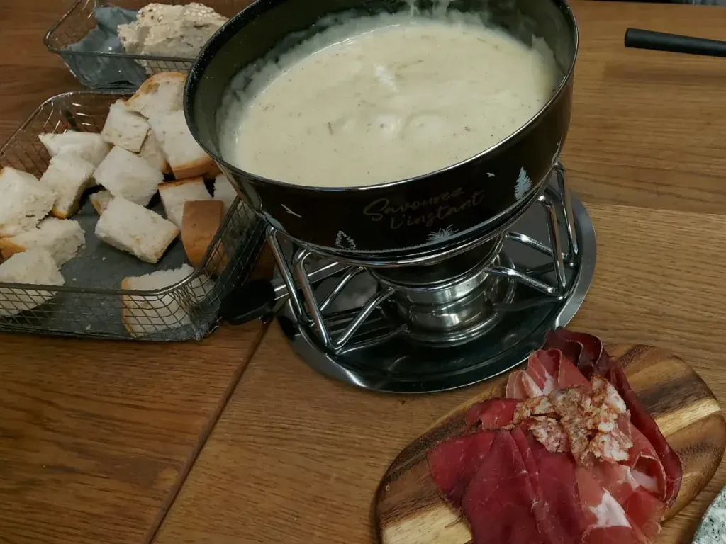 Creamy cheese fondue at Lötschberg Bern in a caquelon on a rechaud with a spirit burner