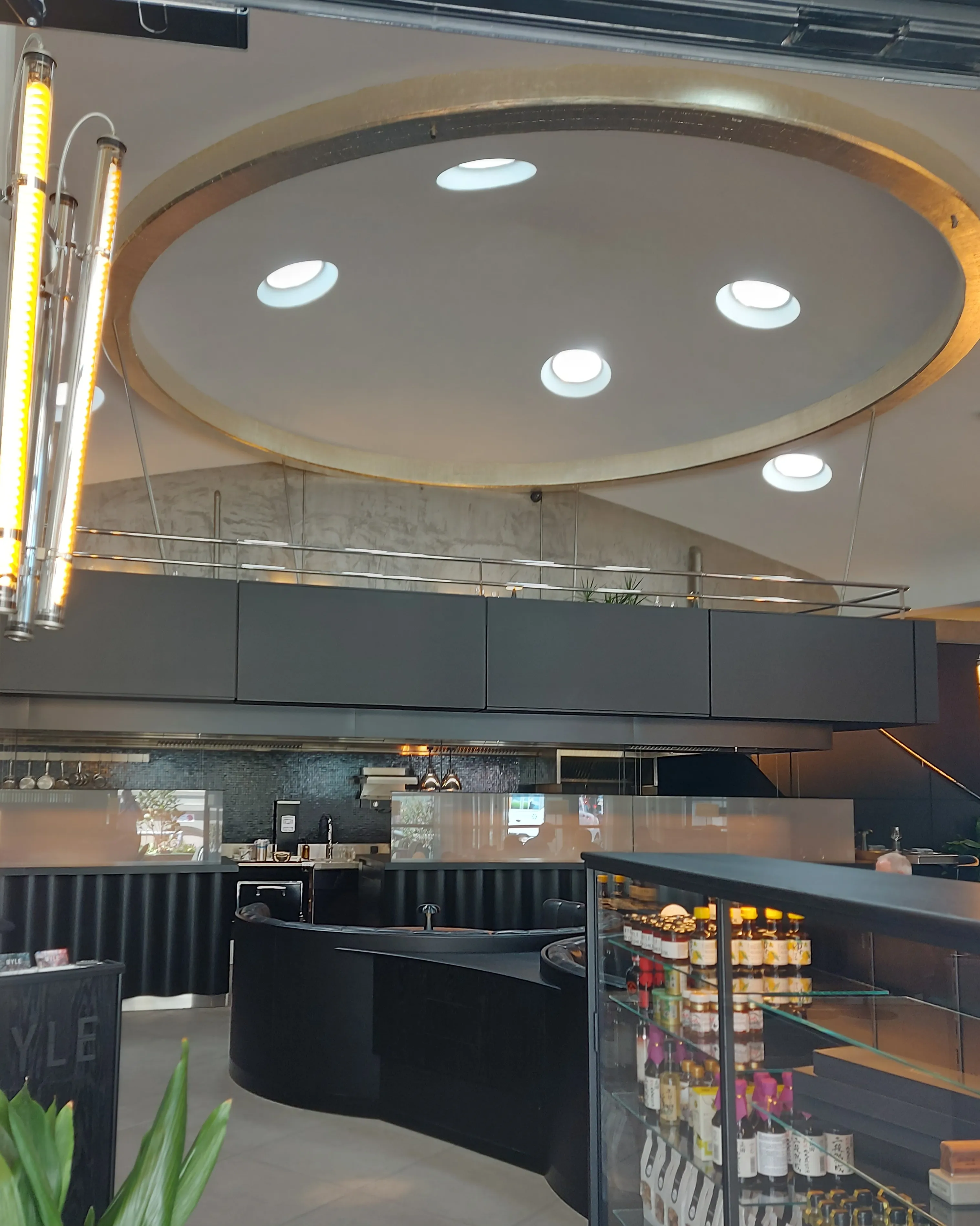 Myle Bern – Innenraum mit eleganten Lampen und schwarzen Lederbänken