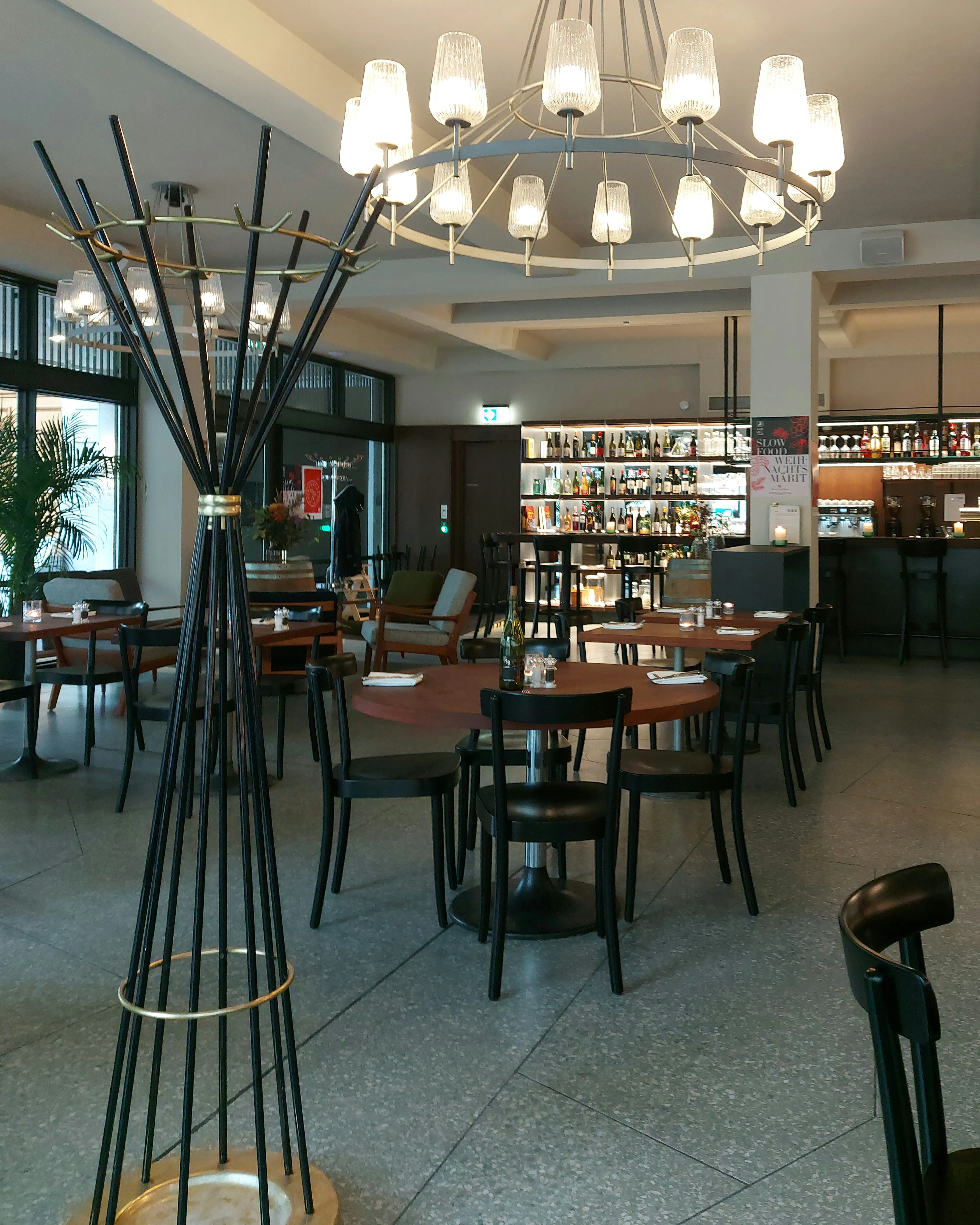Innenraum des Restaurants Schmied mit Holztischen und grossen Glasfenstern