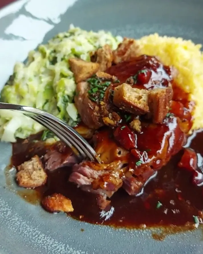 Nahaufnahme der zarten Schweinsbäckchen mit dunklem Jus im Restaurant Schmied Bern