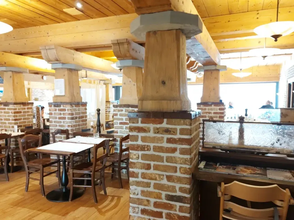 Urchiges Interieur des Tre Fratelli Bern mit Ziegelstein- und Holzstützen