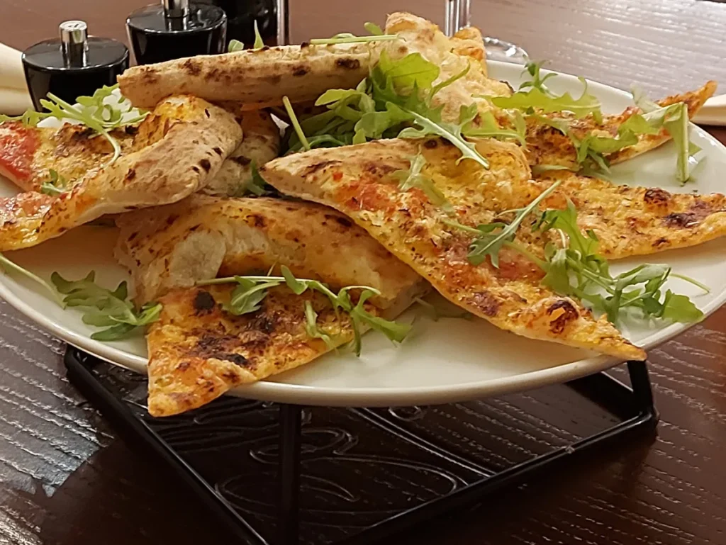 Pizzastücke mit frischem Rucola zum Teilen im Celina Bern