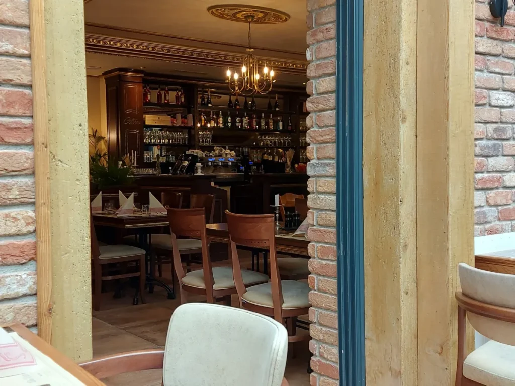 Innenansicht Celina Bern mit Bar aus dunklem Holz, gedeckten Holztischen und Ziegelsteinwänden