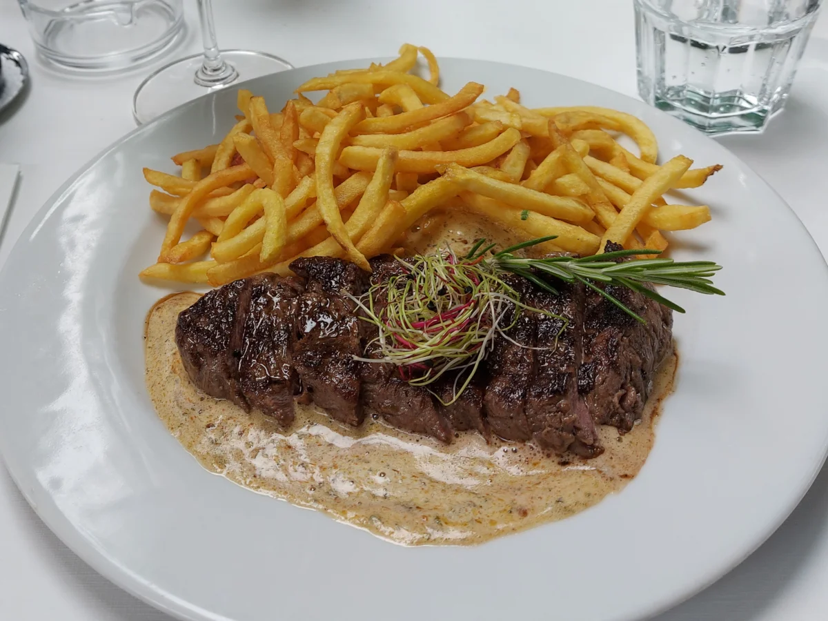 Detailansicht des Signature Dish des Federal Bern: Das Entrecôte mit cremig-schaumiger Café de Paris Sauce, knusprigen Pommes Allumettes und einer Rosmarin-Garnitur.