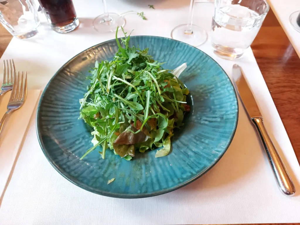 Grosszügige Portion Rucola-Salat auf einem blauen Tonteller im Tre Fratelli Bern.
