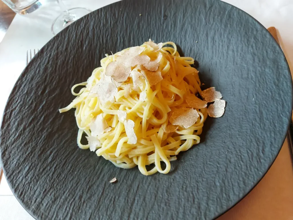 Tagliatelle mit frisch gehobeltem weissem Trüffel auf einem anthrazitfarbenen Teller im Tre Fratelli Bern.